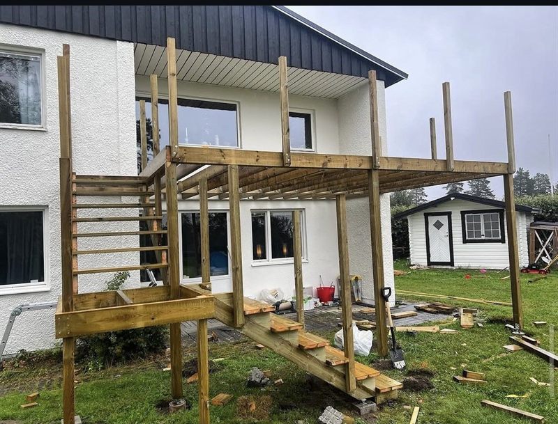 Förlängd balkong i tryckimpregnerat virke med ny trappa ner till trädgården, stommen rest