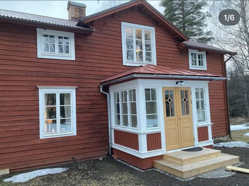 Den färdiga glasverandan på torpet, med vitmålade bågar och gul pardörr
