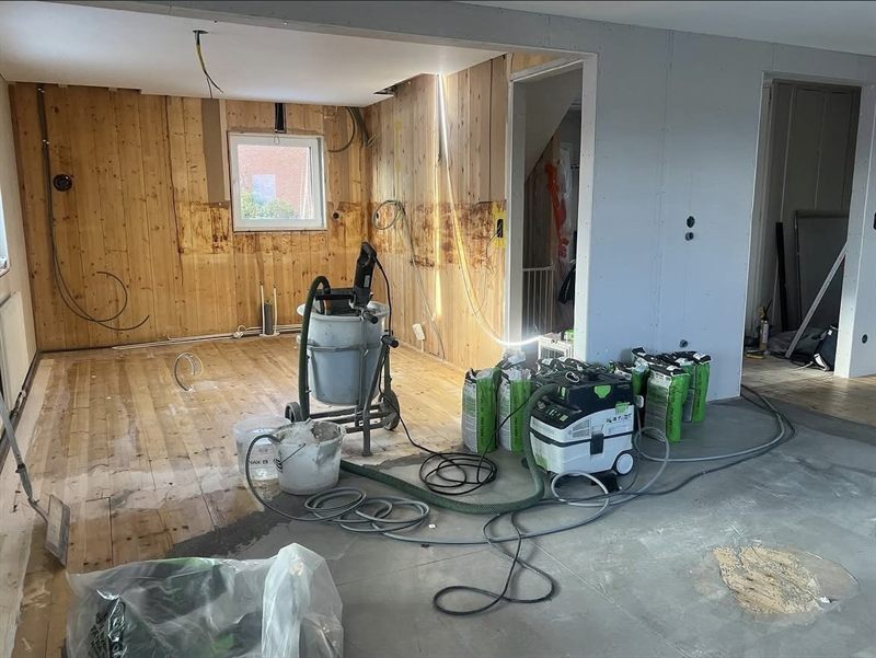 Rummet urrivet till bara träväggar, med golvet uppbrutet och ny el framdragen