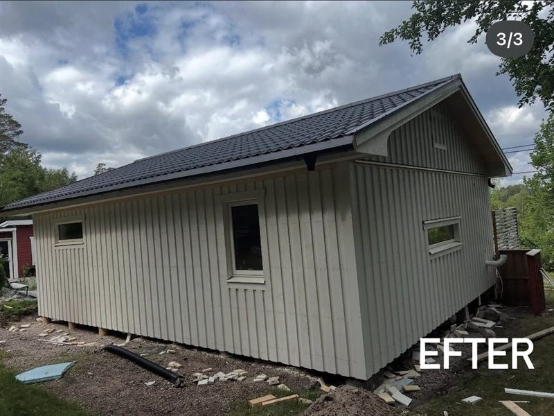 Sommarstugan sedd från gaveln efter renoveringen, med nytt tegeltak och ny panel