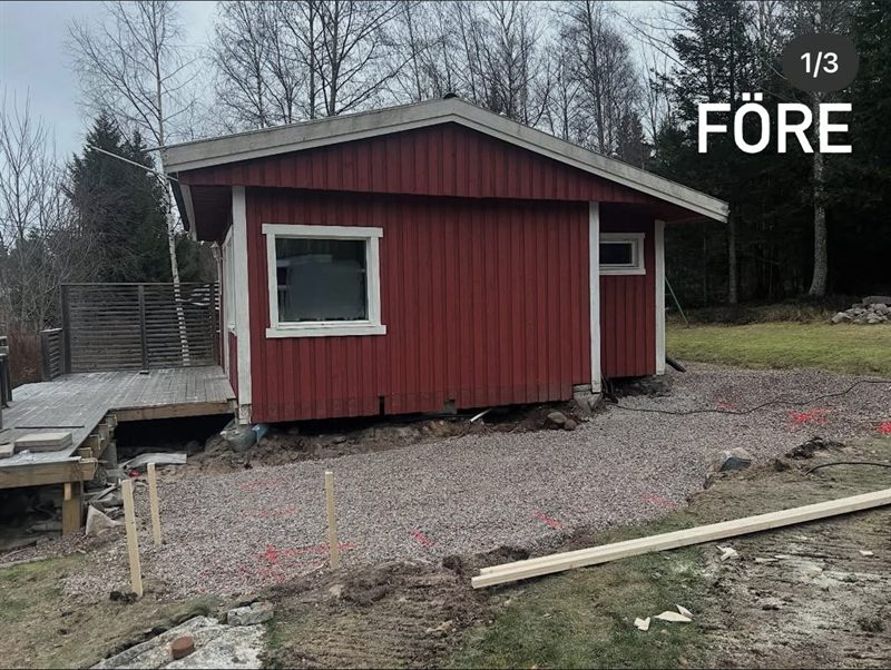 Sommarstugan före renoveringen med sliten röd panel